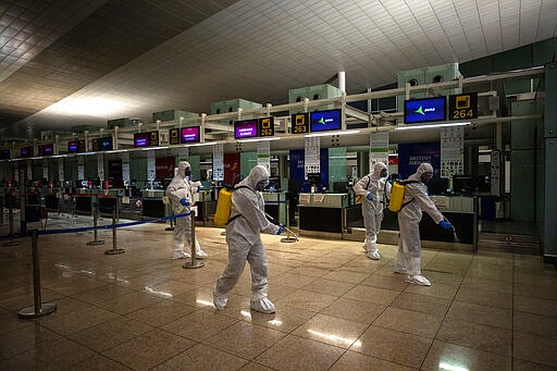 Spanish UME (Emergency Army Unit) soldiers disinfect the terminal one to prevent the spread of COVID-19 at the airport of Barcelona, Spain, Thursday, March 19, 2020. For most people, the new coronavirus causes only mild or moderate symptoms. For some, it can cause more severe illness, especially in older adults and people with existing health problems. (AP Photo/Emilio Morenatti)