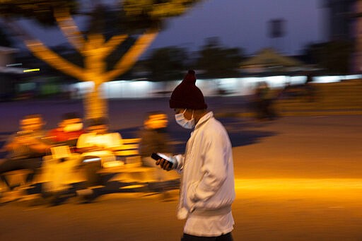 A man wearing a face mask as a precaution against the spread of the new coronavirus, walks near a bus station in Guatemala City, Thursday, March 19, 2020. As part of emergency measures due to the COVID-19 pandemic, the Guatemalan government has restricted public transportation. (AP Photo/Moises Castillo)