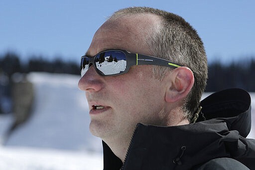 Jon Penoyar wears sunglasses as he looks toward the sledding area at Paradise at Mount Rainier National Park, Wednesday, March 18, 2020, in Washington state. Most national parks are remaining open during the outbreak of the new coronavirus, but many are closing visitor centers, shuttles, lodges and restaurants in hopes of containing its spread. Penoyar said he and his family brought camping food to eat on this visit to the park since the Henry M. Jackson Visitor Center was closed. (AP Photo/Ted S. Warren)