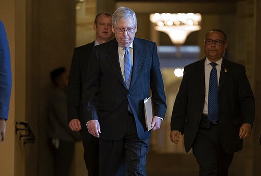 Senate Majority Leader Mitch McConnell, R-Ky., walks to the chamber as lawmakers negotiate on the emergency coronavirus response legislation, at the Capitol in Washington, Wednesday, March 18, 2020. (AP Photo/J. Scott Applewhite)