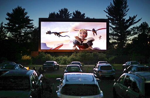 FILE - In this June 26, 2014, file photo, movie-goers watch &quot;How to Train Your Dragon 2,&quot; at the Saco Drive-In in Saco, Maine. The drive-in theater, long a dwindling nostalgia act in a multiplex world, is experiencing a momentary return to prominence. With nearly all of the nation&#146;s movie theaters shuttered due to the pandemic, some drive-ins are the only show in town. (AP Photo/Robert F. Bukaty, File)