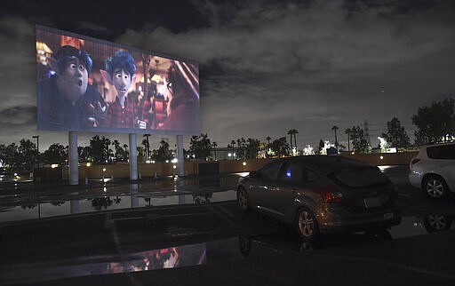 Viewers in a parked car watch the animated film &quot;Onward&quot; at the Paramount Drive-In Theatres, Thursday, March 19, 2020, in Paramount, Calif. The drive-in theater, long a dwindling nostalgia act in a multiplex world, is experiencing a momentary return to prominence. With nearly all of the nation&#146;s movie theaters shuttered due to the pandemic, some drive-in owners think they&#146;re in a unique position to give moviegoers a chance to do something out of the house but stay within prudent distance from one another. (AP Photo/Chris Pizzello)