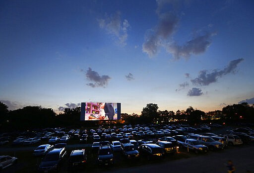 FILE - In this July 26, 2013 file photo, patrons watch a movie as the sun sets over Bengies Drive-In Theatre in Middle River, Md.  The drive-in theater, long a dwindling nostalgia act in a multiplex world, is experiencing a momentary return to prominence. With nearly all of the nation&#146;s movie theaters shuttered due to the pandemic, some drive-ins are the only show in town. (AP Photo/Patrick Semansky, File)