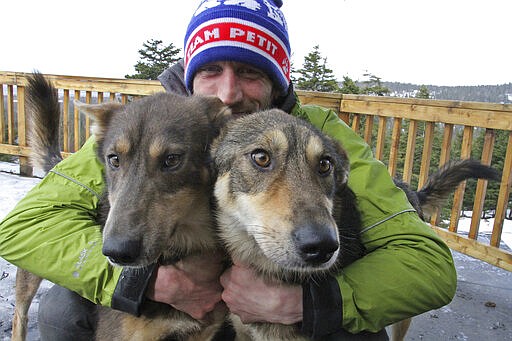 FILE - In this March 20, 2019, file photo, Iditarod musher Nicolas Petit, of France, poses with two of his dogs in Anchorage, Alaska. Nearly a third of the 57 mushers in this year&#146;s Iditarod Trail Sled Dog Race have quit the race before finishing, including Petit, who activated an alert button seeking rescue Thursday morning, March 19, 2020, because of weather conditions. (AP Photo/Mark Thiessen, File)