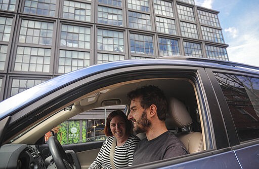 Cailin Sandvig, left, and Justin Bracken prepare to drive away from their home in the Crown Heights area of the Brooklyn borough of New York with their newborn twins, because of the new coronavirus, Monday, March 16, 2020. &quot;We are fleeing the city,&quot; said Sandvig, who works remotely for her job. &quot;We are going to end up in Wheaton, Illinois, where we have a big old house to be in with my mom that's otherwise empty.&quot; (AP Photo/Bebeto Matthews)