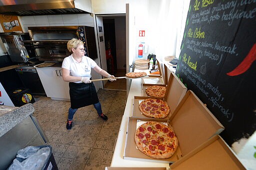 In this photo taken March 18, 2020, Bozena Legowska is making free pizzas for the doctors and medics of the Bielany hospital in Warsaw, Poland, as part of a nationwide action in a gesture of support for their unstopping fight against the spreading coronavirus. Restaurants and eateries remain closed to the public under a &quot;national quarantine&quot; aimed at breaking the human transmission belt for the virus, but they can do deliveries. (AP Photo/Czarek Sokolowski)