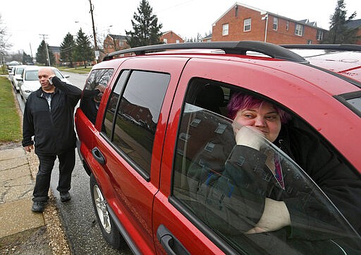 Mark Dowches, left, and Amanda Dowches load their daughter Morgan Dowches' belongings into their vehicle at her apartment, Thursday, March 19, 2020, at Mercyhurst University in Erie, Pa. The family, of Sayre, Pa., left with Morgan last week and returned Wednesday afternoon to find that the university had asked students to quarantine on campus following the discovery of a student who tested positive for COVID-19, the new coronavirus. (Christopher Millette/Erie Times-News via AP)