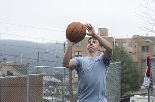 Brady Kokitus, of Pottsville, plays basketball at General Joulwan East Side Park in Pottsville, Pa. on Thursday, March 19, 2020. With schools closed and colleges moving to online courses due to the coronavirus pandemic, Kokitus, a Temple University student, has been spending time training for a triathlon. (Lindsey Shuey/The Republican-Herald via AP)