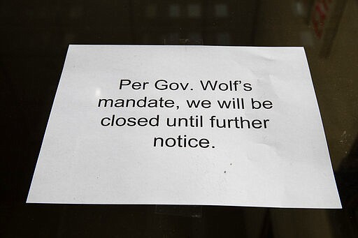 A sign is posted in the window of a closed business in Philadelphia, Friday, March 20, 2020. Gov. Tom Wolf directed all &quot;non-life-sustaining&quot; businesses to close their physical locations late Thursday and said state government would begin enforcement starting early Saturday. (AP Photo/Matt Rourke)