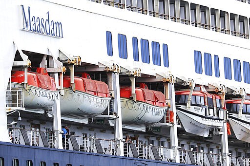 UPDATES THAT SOME PASSENGERS WERE ALLOWED OFF FRIDAY - People are seen aboard the Maasdam cruise liner while it is docked in Honolulu Harbor, for a resupply Friday, March 20, 2020, in Honolulu. Six Hawaii residents were allowed to leave the cruise ship and two other U.S. citizens were allowed to disembark for medical reasons. (AP Photo/Marco Garcia)