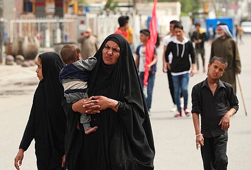 Although shrines are closed due to the new coronavirus, Shiite pilgrims make their way to the shrine of Imam Moussa al-Kadhim, a key Shiite saint, during preparations for the annual commemoration of his death, in Baghdad, Iraq Friday, March 20, 2020. Iraq announced a weeklong curfew to help fight the spread of the virus. For most people, the virus causes only mild or moderate symptoms. For some it can cause more severe illness. (AP Photo/Hadi Mizban)