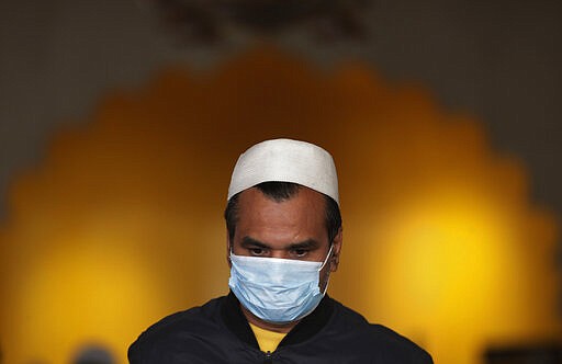 A Nepalese Muslim man wearing face mask as a precaution against COVID-19 offers Friday prayers at Jame mosque in Kathmandu, Nepal, Friday, March 20, 2020. For most people, the new coronavirus causes only mild or moderate symptoms. For some it can cause more severe illness. (AP Photo/Niranjan Shrestha)