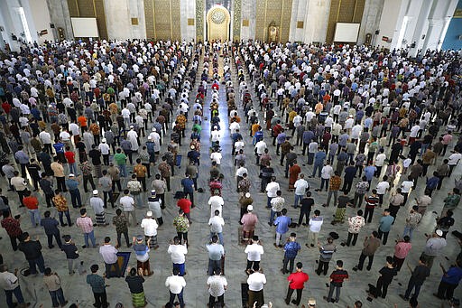 Muslim men perform Friday prayer at the distance of about one meter (3 ft) to each other as a social distancing effort to prevent the spread of new coronavirus outbreak at Al Akbar mosque in Surabaya, East Java, Indonesia, Friday, March 20, 2020. The vast majority of people recover from the new coronavirus. According to the World Health Organization, most people recover in about two to six weeks, depending on the severity of the illness. (AP Photo/Trisnadi)