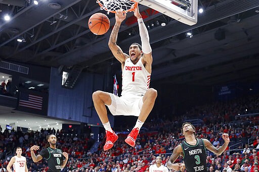 FILE - In this Dec. 17, 2019, file photo, Dayton's Obi Toppin (1) dunks as North Texas' Javion Hamlet (3) looks on during the second half of an NCAA college basketball game in Dayton, Ohio. Toppin is the lone unanimous first-team choice to The Associated Press men's college basketball All-America team, Friday, March 20, 2020. (AP Photo/John Minchillo, File)