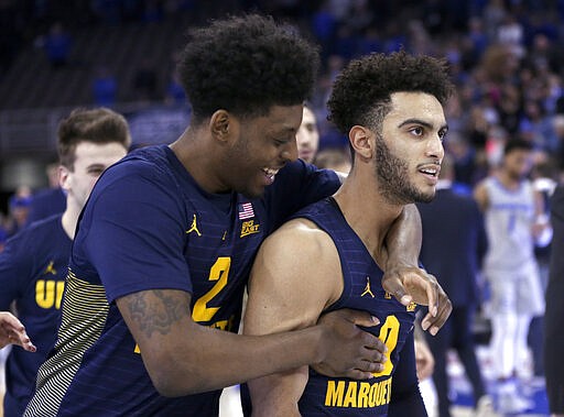 FILE - In this Jan. 9, 2019, file photo, Marquette's Sacar Anim (2), left, celebrates with Markus Howard (0) following the team's NCAA college basketball game against Creighton in Omaha, Neb., Howard was selected to The Associated Press All-America first team, Friday, March 20, 2020.  (AP Photo/Nati Harnik)