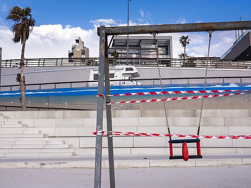 This Thursday, March 19, 2020 photo shows a swin at Tel Aviv's beachfront wrapped in tape to prevent public access. Israel has reported a steady increase in confirmed cases despite imposing strict travel bans and quarantine measures more than two weeks ago. Authorities recently ordered the closure of all non-essential businesses and encouraged people to work from home. (AP Photo/Oded Balilty)