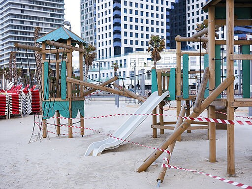 This Thursday, March 19, 2020 photo shows playground at Tel Aviv's beachfront wrapped in tape to prevent public access. Israel has reported a steady increase in confirmed cases despite imposing strict travel bans and quarantine measures more than two weeks ago. Authorities recently ordered the closure of all non-essential businesses and encouraged people to work from home. (AP Photo/Oded Balilty)