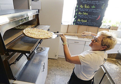 In this photo taken March 18, 2020, Bozena Legowska is making free pizzas for the doctors and medics of the Bielany hospital in Warsaw, Poland, as part of a nationwide action in a gesture of support for their unstopping fight against the spreading coronavirus. Restaurants and eateries remain closed to the public under a &quot;national quarantine&quot; aimed at breaking the human transmission belt for the virus, but they can do deliveries. (AP Photo/Czarek Sokolowski)