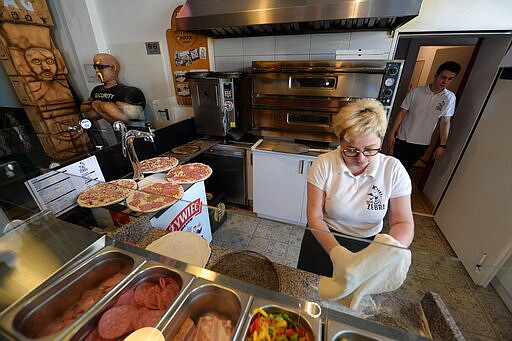 In this photo taken March 18, 2020, Bozena Legowska is making free pizzas for the doctors and medics of the Bielany hospital in Warsaw, Poland, as part of a nationwide action in a gesture of support for their unstopping fight against the spreading coronavirus. Restaurants and eateries remain closed to the public under a &quot;national quarantine&quot; aimed at breaking the human transmission belt for the virus, but they can do deliveries. (AP Photo/Czarek Sokolowski)