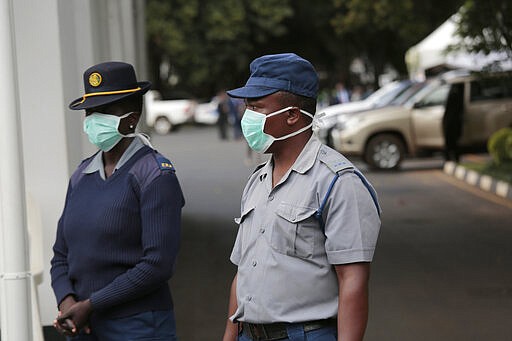 Zimbabwean police wear face masks during a coronavirus awareness campaign launch at State House in Harare, Thursday, March, 19, 2020. For most people, the new coronavirus causes only mild or moderate symptoms. For some it can cause more severe illness, especially in older adults and people with existing health problems. (AP Photo/Tsvangirayi Mukwazhi)