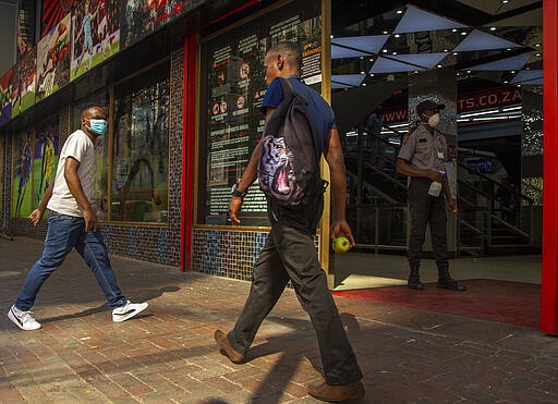 A man wearing a surgical mask walks to a shop in downtown Johannesburg, South Africa, Friday, March 20, 2020. Anxiety rose in Africa&#146;s richest nation Friday as South Africa as coronavirus cases jumped to 202, the most in the sub-Saharan region, while the continent's busiest airport said foreigners cannot disembark. State-owned South African Airways suspended all international flights until June. For most people, the new coronavirus causes only mild or moderate symptoms, such as fever and cough. For some, especially older adults and people with existing health problems, it can cause more severe illness, including pneumonia. (AP Photo/Themba Hadebe)