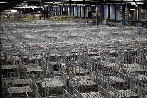 Empty racks are seen at flower auctioneer Royal FloraHolland in Aalsmeer, Netherlands, Thursday, March 19, 2020. Sales at major Dutch growers have slumped, forcing farmers to destroy their flower crops in this busy spring season when bulb fields erupt into color. With lockdowns and border restrictions around the world because of the coronavirus the Netherlands' multibillion dollar flower industry has slumped. For many people the new coronavirus pandemic causes mild or moderate symptoms but for some it can cause severe illness. (AP Photo/Peter Dejong)