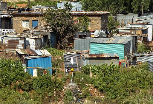 In this photograph taken Thursday March 19, 2020 , A woman spills water at squatter camp in Soweto, South Africa. Some countries around the world lack the equipment and trained health workers to respond to the threat of COVID-19 virus. For most people the virus causes mild or moderate symptoms, but for others it causes severe illness.  (AP Photo/Themba Hadebe)