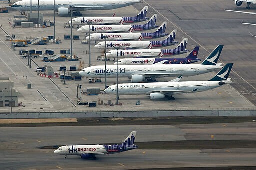 In this March 6, 2020, photo, Cathay Pacific and Hong Kong Express aircraft line up on the tarmac at the Hong Kong International Airport. Hong Kong low-cost airline HK Express, part of the Cathay Pacific Group, said Friday, March 20, 2020 it was suspending all flights through the end of April due to falling demand amid the coronavirus outbreak. (AP Photo/Kin Cheung)