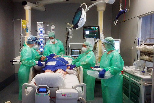 Medical staff assist a patient in the Intensive Care Unit of the Bergamo Papa Giovanni XXIII hospital, Italy, Tuesday, March 17, 2020. For most people, the new coronavirus causes only mild or moderate symptoms. For some it can cause more severe illness, especially in older adults and people with existing health problems.(ASST Papa Giovanni XXIII via AP)