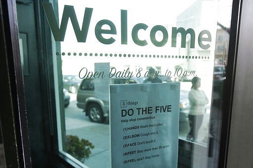 A sign about preventing the spread of the coronavirus is posted on the door of The Green Cross cannabis dispensary in San Francisco, Wednesday, March 18, 2020. As about 7 million people in the San Francisco Bay Area are under shelter-in-place orders, only allowed to leave their homes for crucial needs in an attempt to slow virus spread, marijuana stores remain open and are being considered &quot;essential services.&quot; (AP Photo/Jeff Chiu)