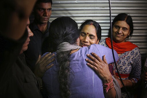 Asha Devi, mother of the victim of the fatal 2012 gang rape on a moving bus, facing camera, is embraced by an unidentified woman after the rapists of her daughter were hanged in New Delhi, India, Friday, March 20, 2020. Four men were sentenced to capital punishment for the 2012 gang-rape of a 23-year-old physiotherapy student on a moving bus in New Delhi have been executed. (AP Photo/Altaf Qadri)
