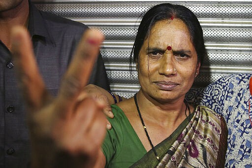 Asha Devi, mother of the victim of the fatal 2012 gang rape on a moving bus, displays a victory sign after the rapists of her daughter were hanged, in New Delhi, India, Friday, March 20, 2020. Four men were sentenced to capital punishment for the 2012 gang-rape of a 23-year-old physiotherapy student on a moving bus in New Delhi have been executed. (AP Photo/Altaf Qadri)