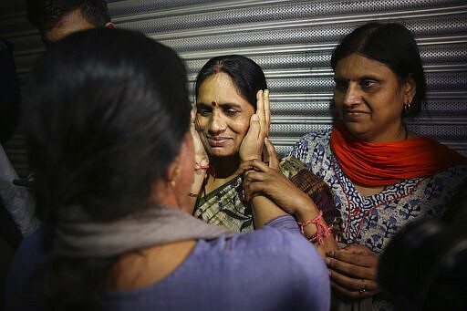 Asha Devi, mother of the victim of the fatal 2012 gang rape on a moving bus, facing camera, is comforted by an unidentified woman, left, after the rapists of her daughter were hanged, in New Delhi, India, Friday, March 20, 2020. Four men were sentenced to capital punishment for the 2012 gang-rape of a 23-year-old physiotherapy student on a moving bus in New Delhi have been executed. (AP Photo/Altaf Qadri)
