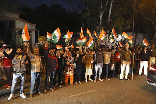 Indians hold national flags and shout slogans outside Tihar central prison where four men were sentenced to capital punishment in New Delhi, India, Friday, March 20, 2020. Four men sentenced to death for the gruesome gang rape and murder of a woman on a New Delhi bus in 2012 were hanged Friday, concluding a case that exposed the scope of sexual violence against women in India and prompted horrified Indians to demand swift justice. (AP Photo/Manish Swarup)