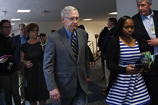 Senate Majority Leader Mitch McConnell of Ky., is followed by reporters and staff as he leaves a meeting on Capitol Hill in Washington, Friday, March 20, 2020, to work on an economic package to deal with the coronavirus. (AP Photo/Susan Walsh)