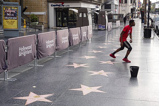 With no tourists or crowds to perform for along Hollywood Boulevard, Jonte Florence works on his moves near Hollywood and Highland in Los Angeles on Thursday, March 19, 2020. The coronavirus has closed restaurants, stores, theaters and many commuters are now working from home. (David Crane/The Orange County Register/SCNG via AP)