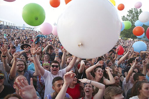 FILE - In this May 6, 2018 file photo fans take in The Flaming Lips performance at Beale Street Music Festival in Memphis, Tenn. The Beale Street Music Festival and the World Championship Barbecue Cooking Contest in Memphis have been postponed because of the new coronavirus outbreak. Memphis in May officials said in a statement Thursday, March 19, 2020 that the two cornerstones of the city's month-long tourist event have been called off but will be rescheduled for later dates. (Photo by Laura Roberts/Invision/AP, file)