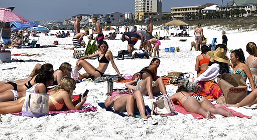 Students from Clemson University lie on the beach during spring break near Pompano Joe's Restaurant in Miramar Beach near Destin, Fla., on Monday, March 16, 2020. Speaking about the coronavirus, Ellis Turner said, &quot;I feel safer here than at school,&quot; noting they live in a residential hall at school where everybody is touching the same stuff. (Tina Harbuck/Northwest Florida Daily News via AP)