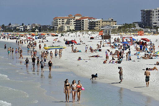 Visitors enjoy Clearwater Beach, Wednesday, March 18, 2020, in Clearwater Beach, Fla. Beach goers are keeping a safe distance from each other to help protect from the spread of the Coronavirus. (AP Photo/Chris O'Meara)