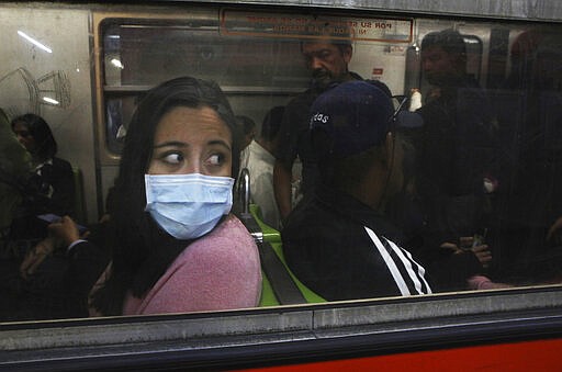 A commuter in the metro wears a protective mask as a precaution against the spread of the new coronavirus in Mexico City, Thursday, March 19, 2020. (AP Photo/Marco Ugarte)