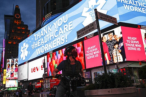 A screen displaying a messages thanking healthcare workers due to COVID-19 concerns is displayed in a sparsely populated Times Square, Friday, March 20, 2020, in New York. New York Gov. Andrew Cuomo is ordering all workers in non-essential businesses to stay home and banning gatherings statewide. &quot;Only essential businesses can have workers commuting to the job or on the job,&quot; Cuomo said of an executive order he will sign Friday. Nonessential gatherings of individuals of any size or for any reason are canceled or postponed. (AP Photo/John Minchillo)