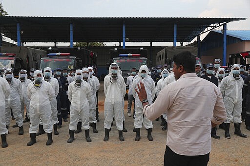 Director Disaster Response Force of Telangana State Vishwajeet Kampati gives instructions to members of his team prior to spraying disinfectants as a precautionary measure against COVID-19 in Hyderabad, India, Friday, March 20, 2020. For most people, the new coronavirus causes only mild or moderate symptoms. For some it can cause more severe illness. (AP Photo/Mahesh Kumar A.)