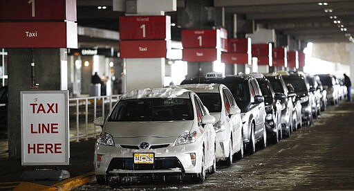 Taxi cabs sit idle at the stand as drivers wait for passengers outside Denver International Airport where there are few travelers as people deal with the spread of coronavirus Friday, March 20, 2020, in Denver. According to the World Health Organization, most people recover in about two to six weeks depending on the severity of the COVID-19 illness. (AP Photo/David Zalubowski)