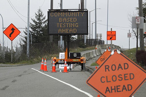 A sign directs vehicles toward a drive-up testing site at the Tacoma Dome in Tacoma, Wash., Saturday, March 21, 2020. The Tacoma-Pierce County Health Department is hosting the testing for the new coronavirus over the next several days for people at higher risk for COVID-19 and people with symptoms who work in healthcare, public safety, and for critical businesses such as grocery stores and public utilities. (AP Photo/Ted S. Warren)