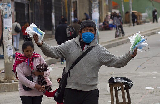 A man wearing a face mask as a preventive measure against the spread of the new coronavirus sells protective face masks in El Alto, Bolivia, Thursday, March 19, 2020. The vast majority of people recover from COVID-19. (AP Photo/Juan Karita)