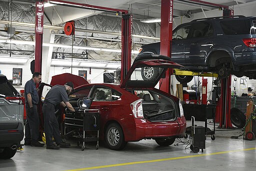 Laurel Toyota mechanics, from left, Rich Grayish and Steve Dunn work on a hybrid car recall on a Toyota Prius at the Johnstown, Pa., Toyota dealership, Friday, March 20, 2020. Pennsylvania Gov. Tom Wolf announced a list of non-essential businesses that are being told to close to contain the spread of coronavirus. Car dealerships are allowed to keep their auto repairs shops open. (Todd Berkey/The Tribune-Democrat via AP)