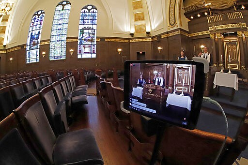 Rodef Shalom Rabbi Aaron Bisno, right, delivers his sermon during an Erev Shabbot service that is being streamed live on Facebook, Friday, March 20, 2020. All events have been suspended at the synagogue until April 16, to help mitigate the spread of the COVID-19 virus. (AP Photo/Gene J. Puskar)