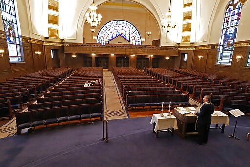 Rodef Shalom Rabbi Aaron Bisno, right, delivers his sermon during an Erev Shabbot service that is being streamed live on Facebook, Friday, March 20, 2020. All events have been suspended at the synagogue until April 16, to help mitigate the spread of the COVID-19 virus. (AP Photo/Gene J. Puskar)