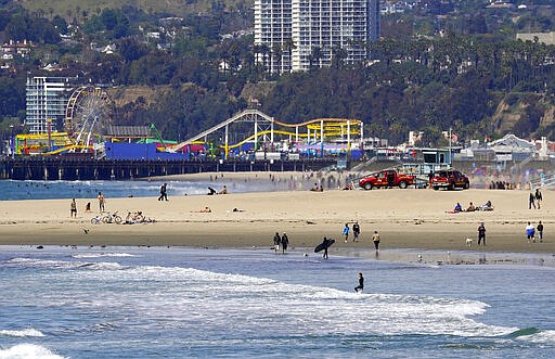 Beachgoers are seen at Venice Beach, Saturday, March 21, 2020, in Los Angeles. Traffic would normally be bumper-to-bumper during this time of day on a Friday. California Gov. Gavin Newsom ordered the state's 40 million residents to stay at home indefinitely. His order restricts non-essential movements to control the spread of the coronavirus that threatens to overwhelm the state's medical system. (AP Photo/Mark J. Terrill)