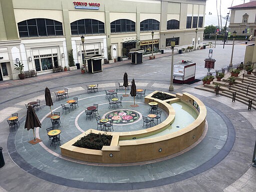 A plaza at The Paseo, an upscale outdoor shopping mall in Pasadena, Calif., is deserted Saturday, March 21, 2020, after state and local authorities told Californians to stay at home and maintain social distancing to reduce the spread of the coronavirus. (AP Photo/John Antczak)